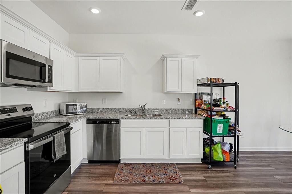 625 Jervis Way Locust Grove, GA 30248 - Photo 12 of 28 a kitchen with stainless steel appliances granite countertop a stove a sink and a microwave