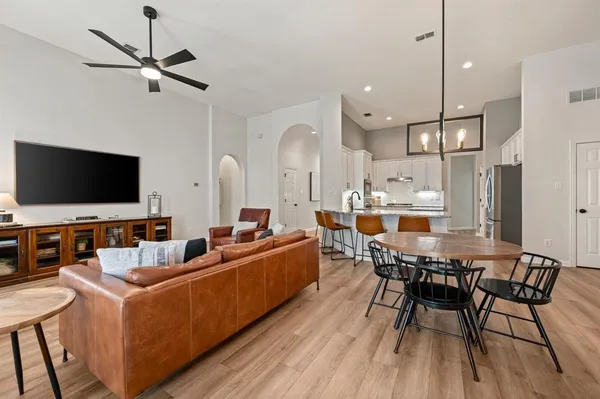 a living room with furniture a flat screen tv and kitchen view