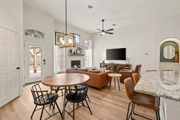 a view of a dining room with furniture a fireplace and wooden floor