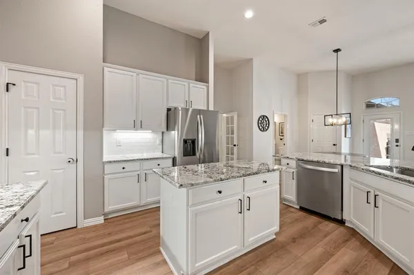 a kitchen with stainless steel appliances a sink cabinets and wooden floor