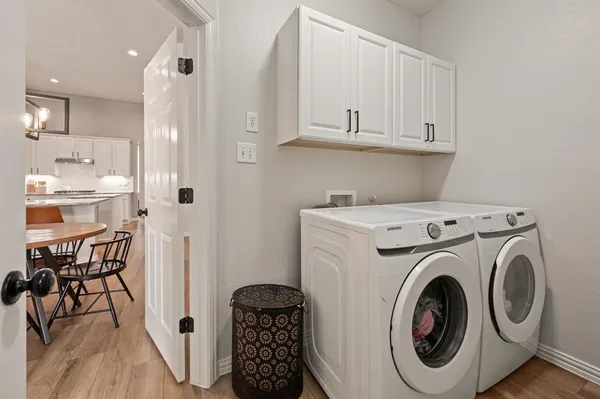 a view of washer and dryer with kitchen in the background