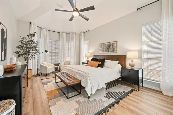 a spacious bedroom with a bed and a chandelier
