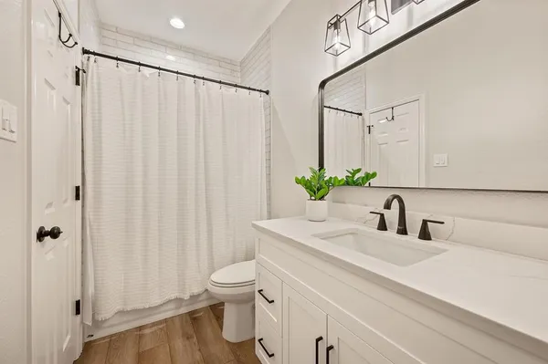 a bathroom with a sink a toilet and shower curtain