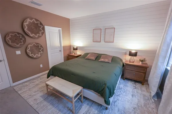 a bedroom with a bed and painting on the wall