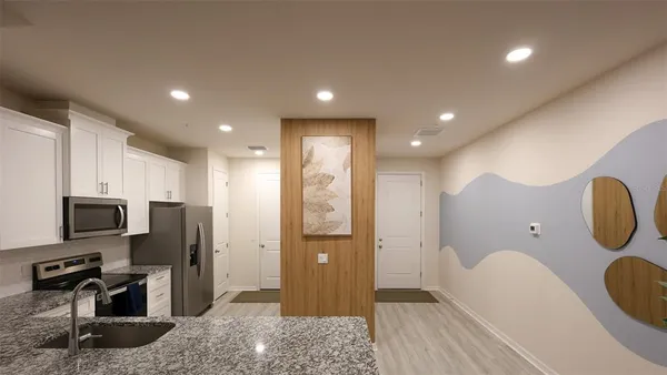 a spacious bathroom with a granite countertop sink a toilet a mirror and shower