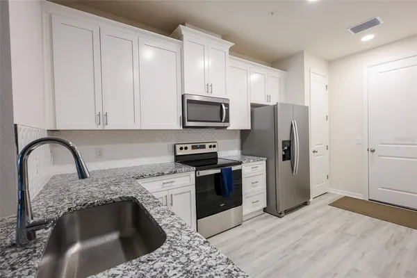 a kitchen with a refrigerator sink and stove