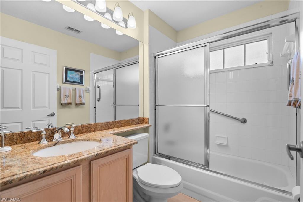 2255 Harmony Lane, Unit 204 Naples, FL 34109 - Photo 20 of 32 a bathroom with a granite countertop sink toilet and shower