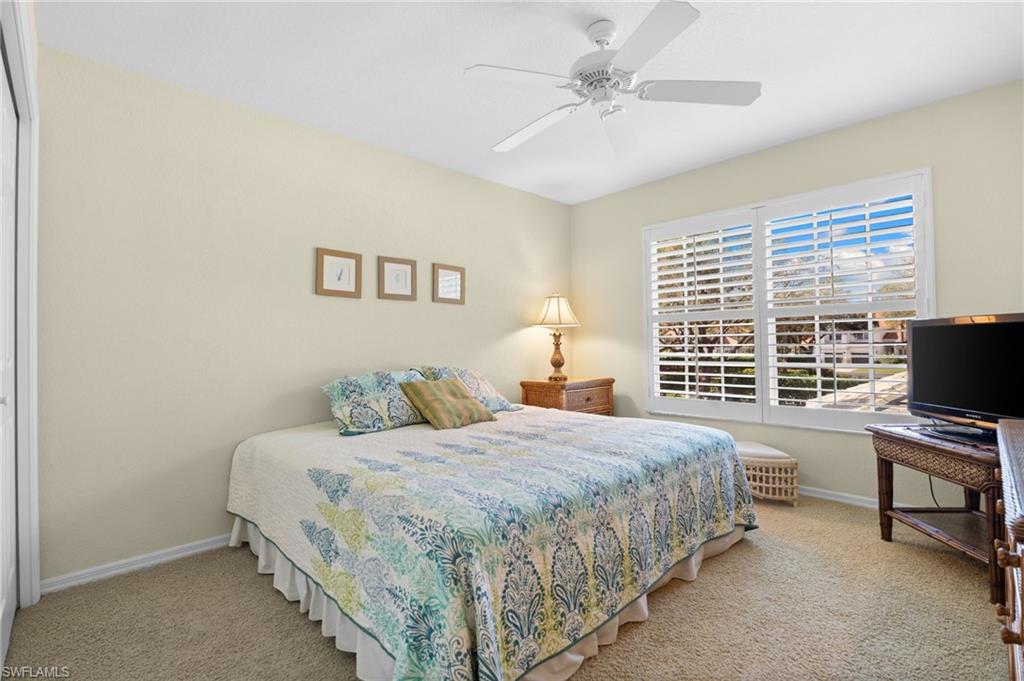 2255 Harmony Lane, Unit 204 Naples, FL 34109 - Photo 21 of 32 a bedroom with a bed furniture and a flat screen tv