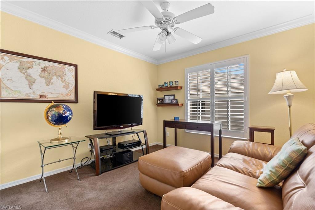 2255 Harmony Lane, Unit 204 Naples, FL 34109 - Photo 22 of 32 a living room with furniture and a flat screen tv
