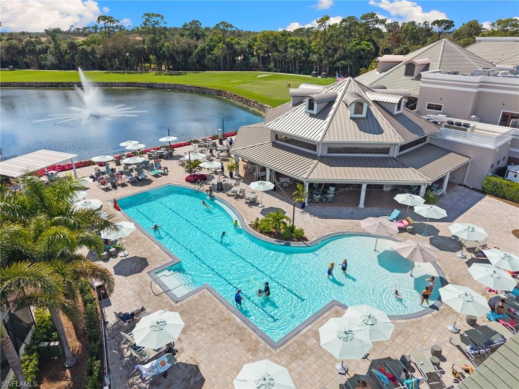 2255 Harmony Lane, Unit 204 Naples, FL 34109 - Photo 29 of 32 a view of a lake with couches chair and umbrella