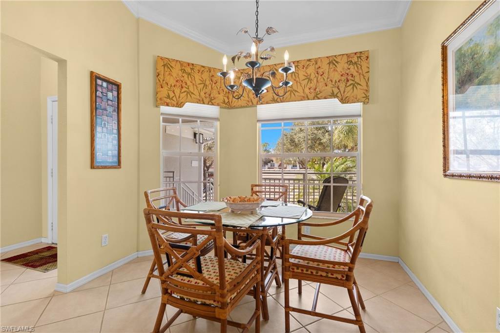 2255 Harmony Lane, Unit 204 Naples, FL 34109 - Photo 4 of 32 a view of a dining room with furniture wooden floor and chandelier