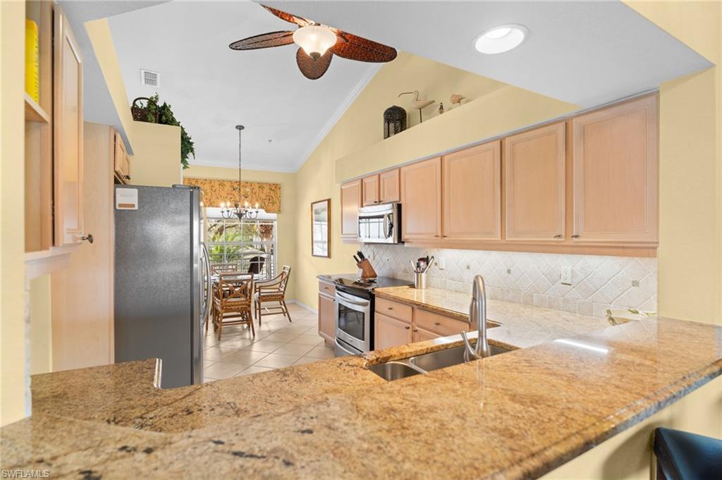 2255 Harmony Lane, Unit 204 Naples, FL 34109 - Photo 6 of 32 a kitchen with stainless steel appliances granite countertop a sink refrigerator stove and microwave