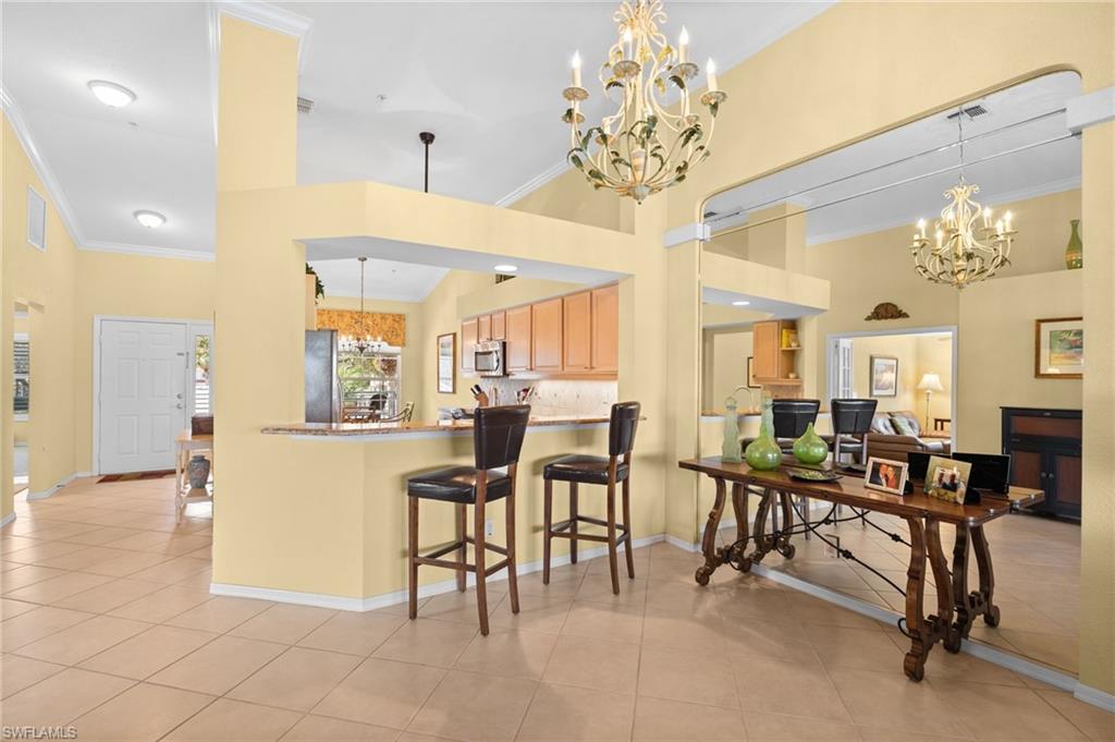 2255 Harmony Lane, Unit 204 Naples, FL 34109 - Photo 9 of 32 a view of a dining room with furniture and a chandelier
