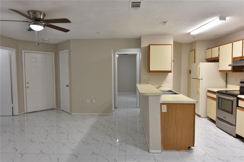 956 Salt Pond Place, Unit 303 Altamonte Springs, FL 32714 - Photo 11 of 17 a view of kitchen and empty room with wooden floor