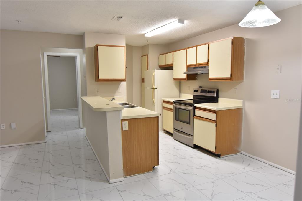 956 Salt Pond Place, Unit 303 Altamonte Springs, FL 32714 - Photo 6 of 17 a kitchen with a sink stove and cabinets