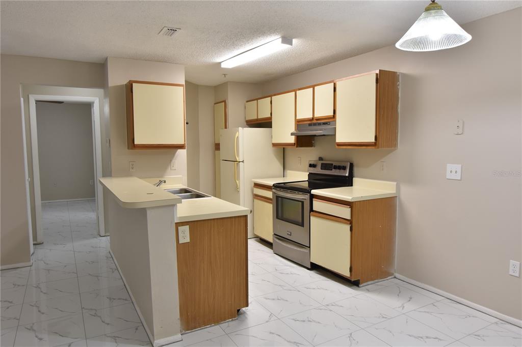 956 Salt Pond Place, Unit 303 Altamonte Springs, FL 32714 - Photo 8 of 17 a kitchen with a sink stove and cabinets