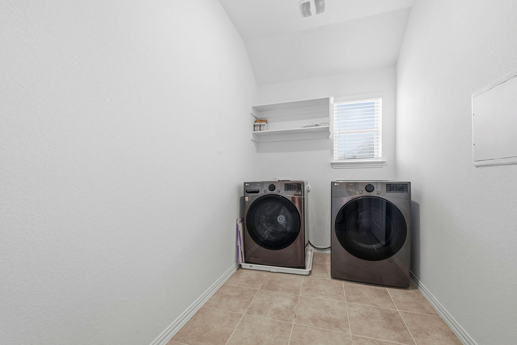 1005 Ridge Runner Drive Georgetown, TX 78628 - Photo 18 of 32 Laundry room featuring tiled flooring, a window with horizontal blinds, and a built-in wall shelf