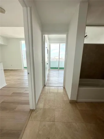 a view of a hallway with wooden floor and entryway