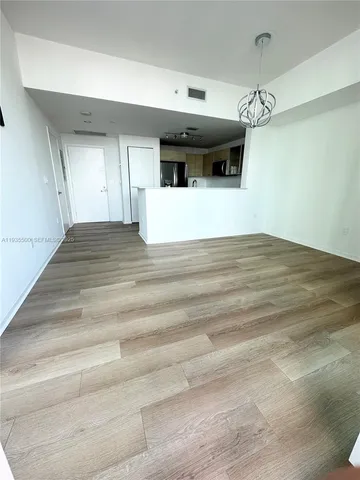 a view of a hallway with a microwave and a ceiling fan