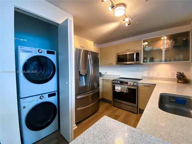 a kitchen with stainless steel appliances granite countertop a stove a washer and dryer
