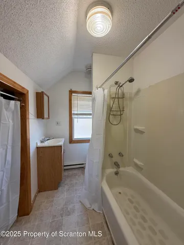 a bathroom with a tub a sink and a shower