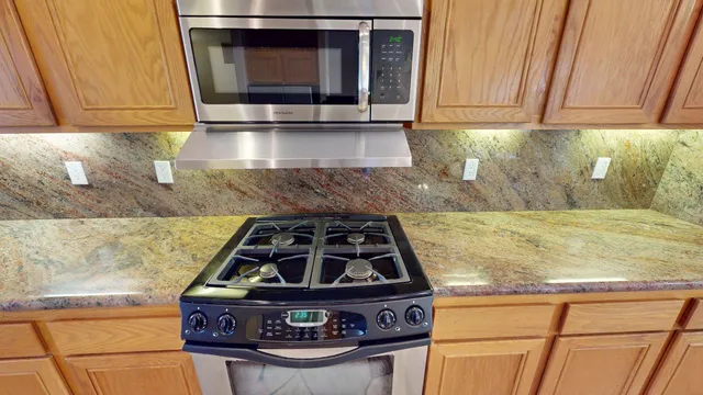 a kitchen with stainless steel appliances granite countertop a refrigerator and a sink