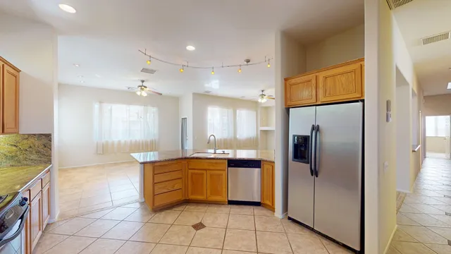 a large kitchen with stainless steel appliances granite countertop a sink and cabinets