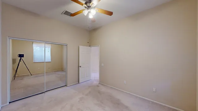 a view of an empty room with window and a kitchen
