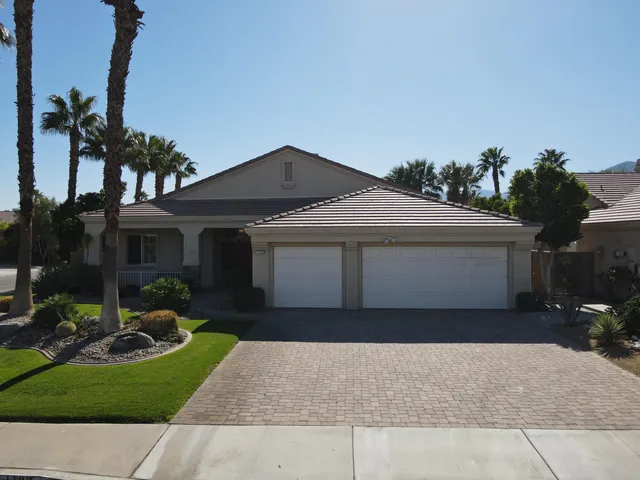 a front view of a house with a yard and potted plants