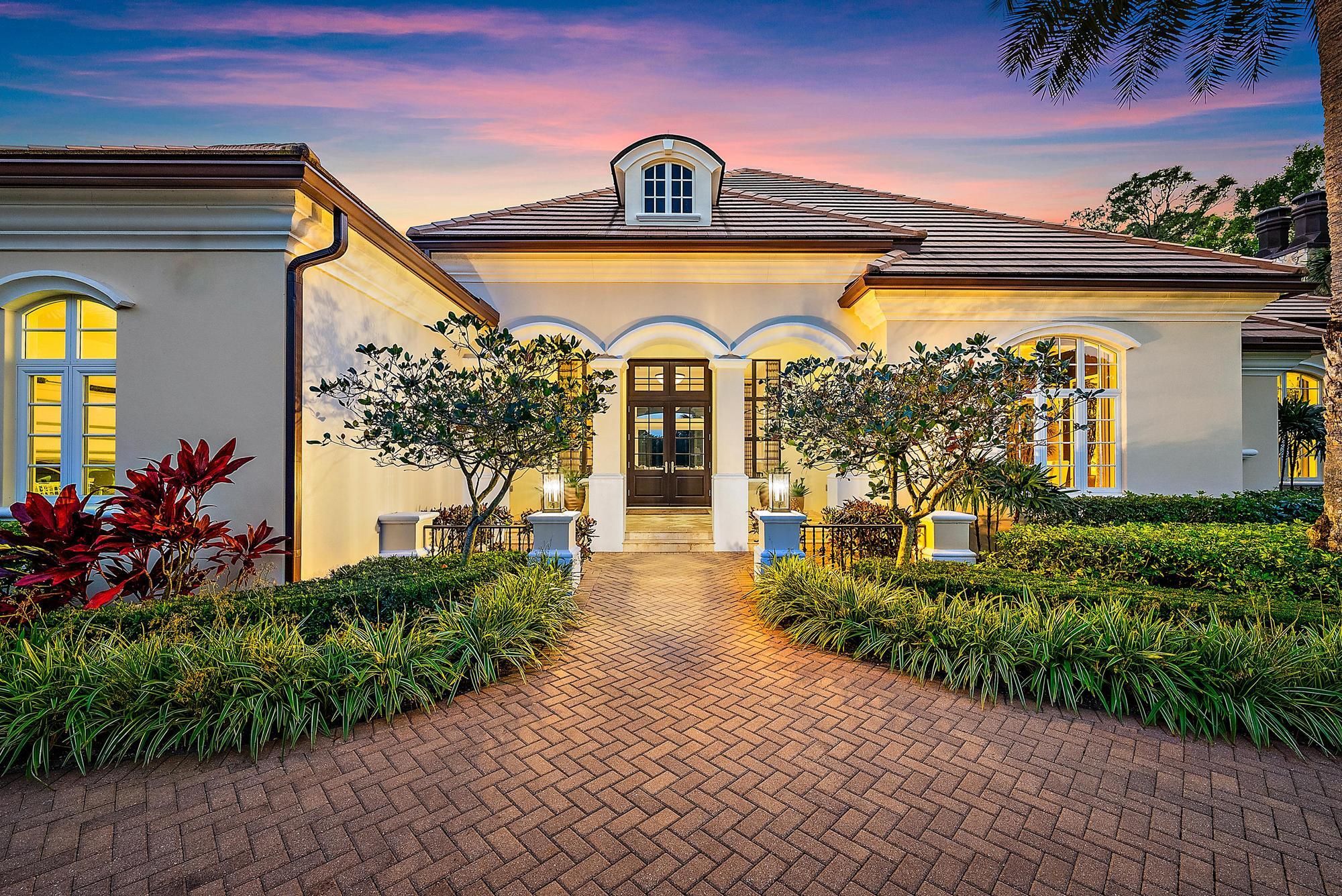 7770 Old Marsh Road Palm Beach Gardens, FL 33418 - Photo 2 of 45 a front view of a house with garden