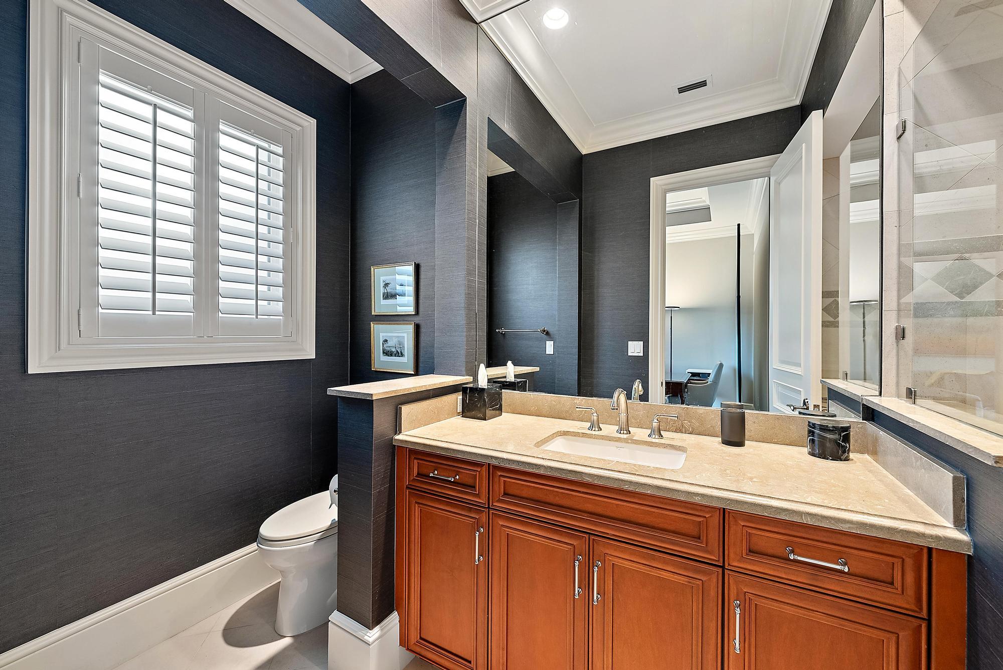 7770 Old Marsh Road Palm Beach Gardens, FL 33418 - Photo 32 of 45 a bathroom with a sink a toilet and a mirror