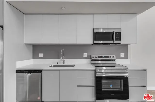 a kitchen with stainless steel appliances granite countertop a sink stove and microwave