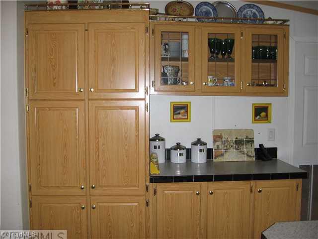 1183 Kallam Farm Road Sandy Ridge, NC 27046 - Photo 9 of 16 Kitchen. Door to Walk-in Pantry & Glas Door Cabinets