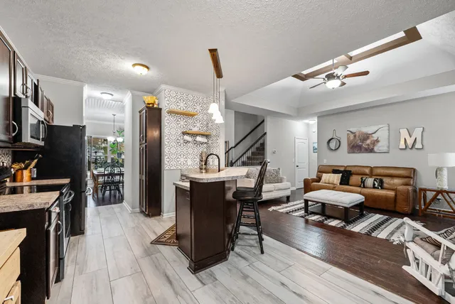 a living room with furniture a piano and a flat screen tv