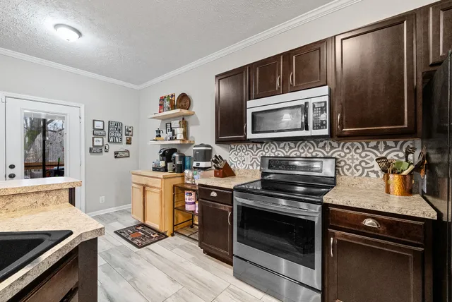a kitchen with granite countertop a stove and a microwave