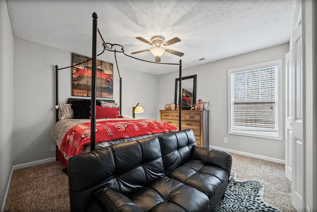 a bedroom with a bed a couch and dresser