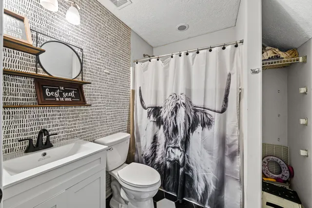 a bathroom with a toilet a sink and a mirror