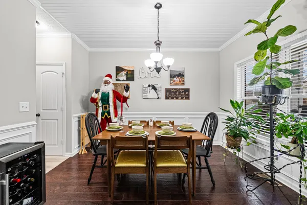 a dining room with furniture potted plants and wooden floor