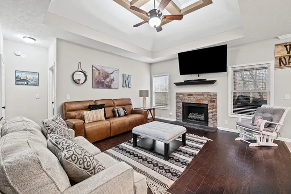 a living room with furniture a flat screen tv and a fireplace