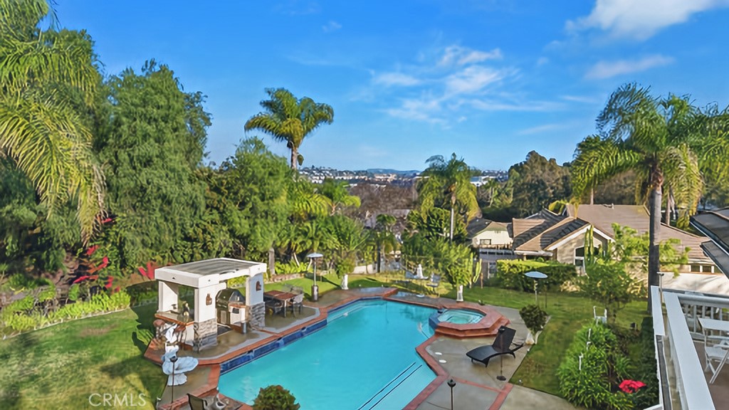 25641 Rapid Falls Road Laguna Hills, CA 92653 - Photo 2 of 50 a view of a swimming pool with lawn chairs under an umbrella