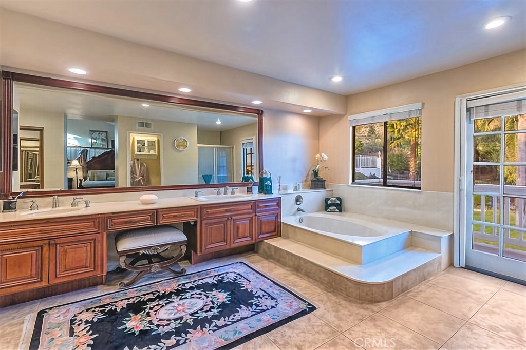 25641 Rapid Falls Road Laguna Hills, CA 92653 - Photo 40 of 50 a spacious bathroom with a double vanity sink a mirror a bathtub and next to a window