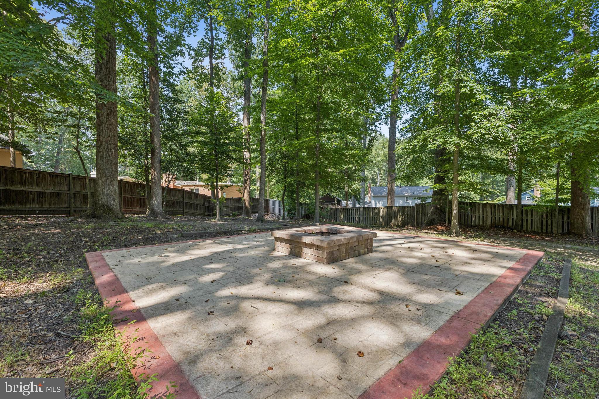 3404 Holly Circle Triangle, VA 22172 - Photo 4 of 68 Serene fire pit nestled in lush greenery.