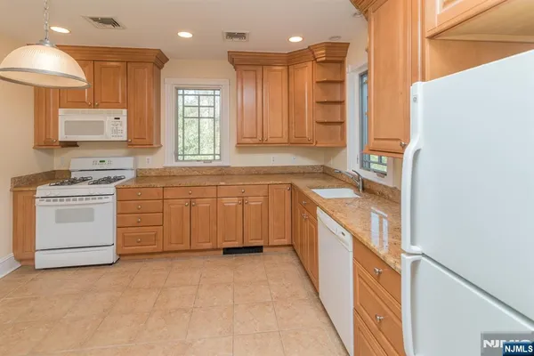 a bathroom with a granite countertop sink a mirror and a shower