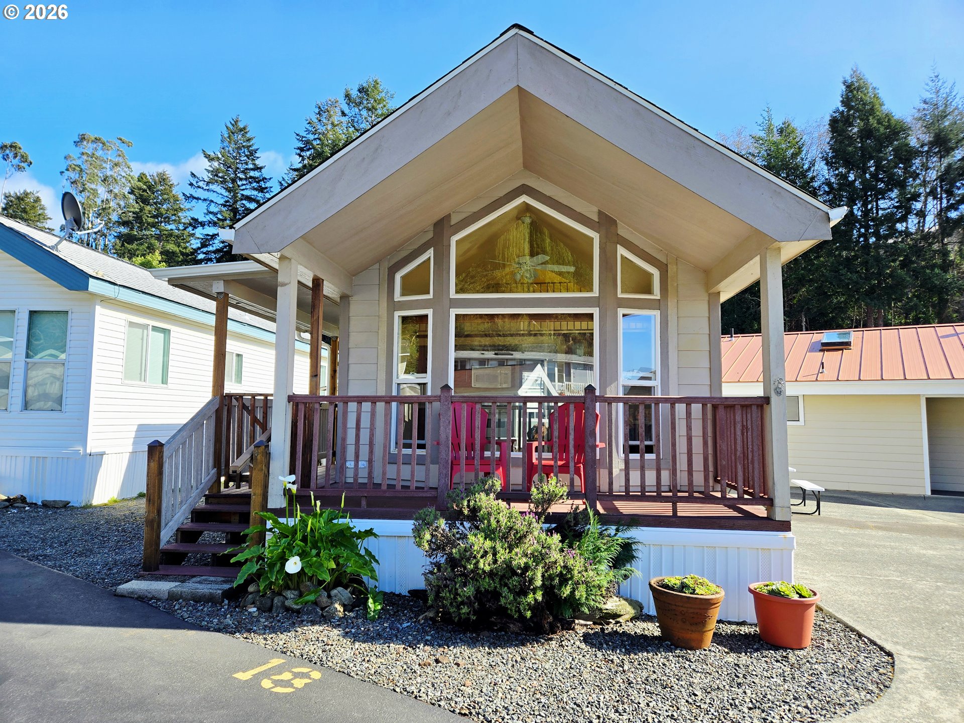 16219 Lower Harbor Road, Unit 18 Brookings, OR 97415 - Photo 1 of 38 a view of a house with wooden walls and potted plants