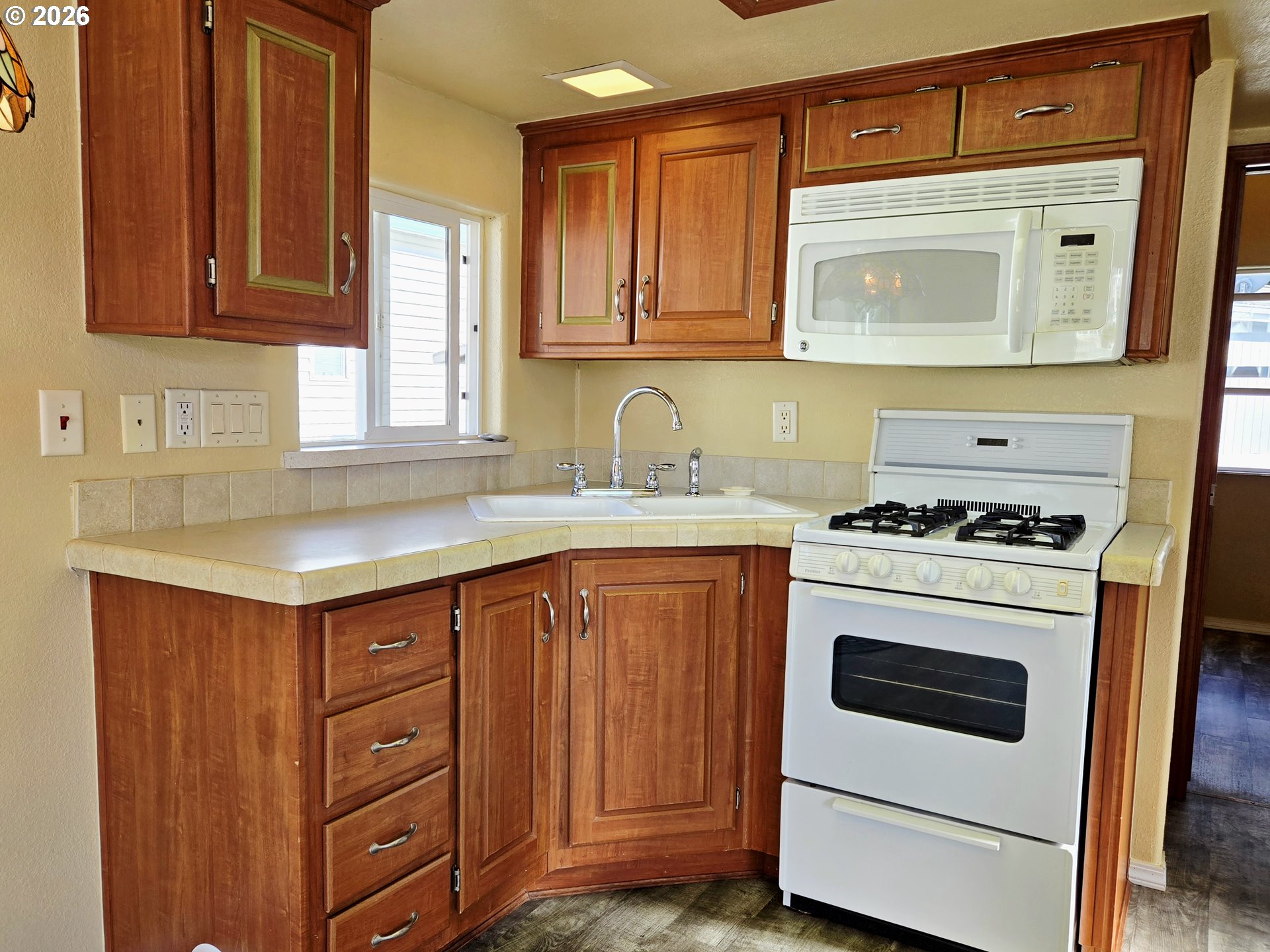16219 Lower Harbor Road, Unit 18 Brookings, OR 97415 - Photo 18 of 38 a kitchen with granite countertop a sink cabinets stainless steel appliances and a window