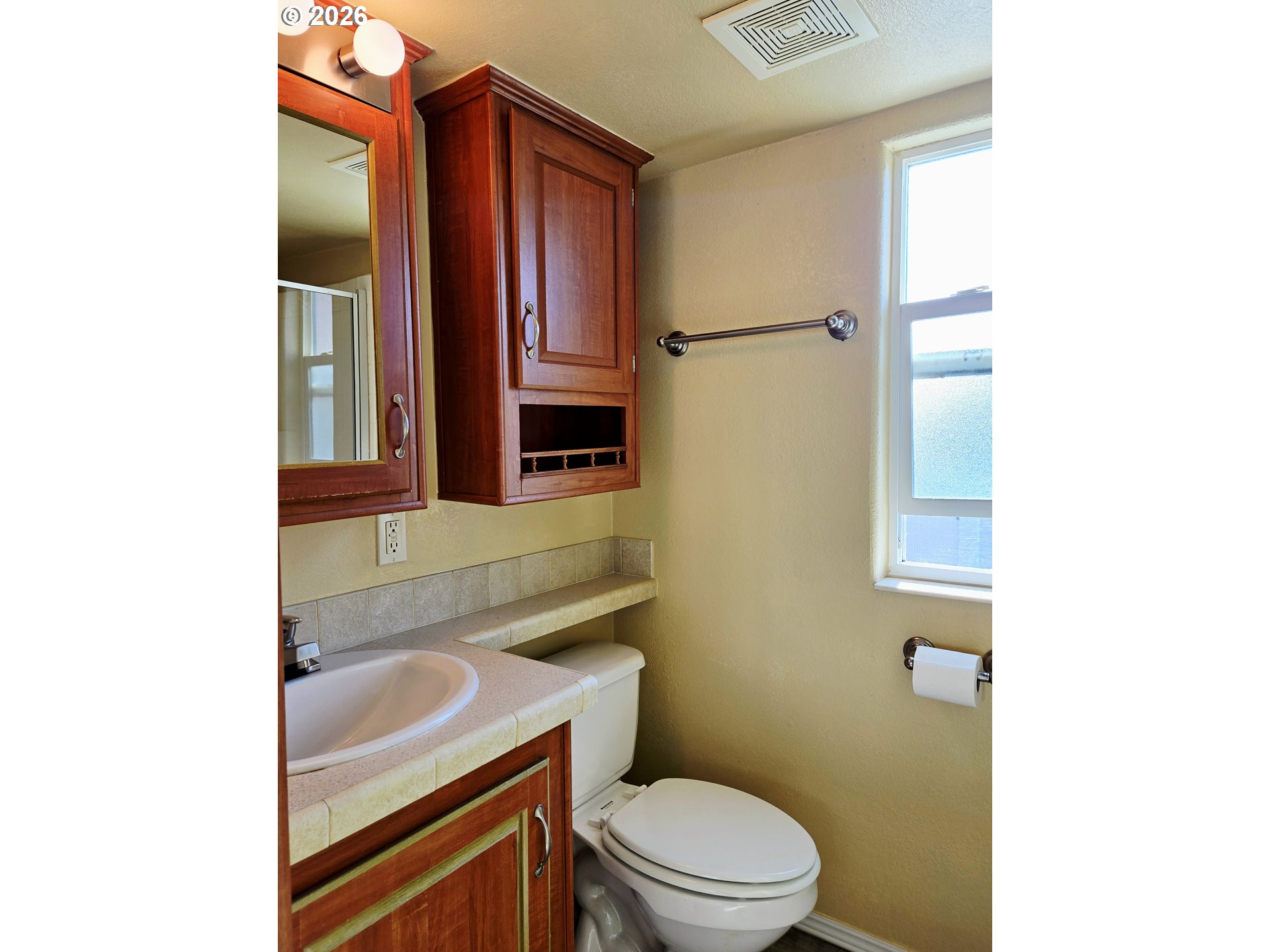 16219 Lower Harbor Road, Unit 18 Brookings, OR 97415 - Photo 21 of 38 a bathroom with a sink a toilet and mirror