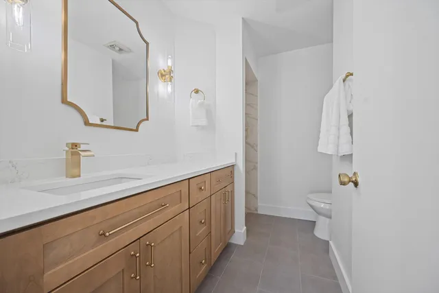 a bathroom with a granite countertop shower sink and mirror