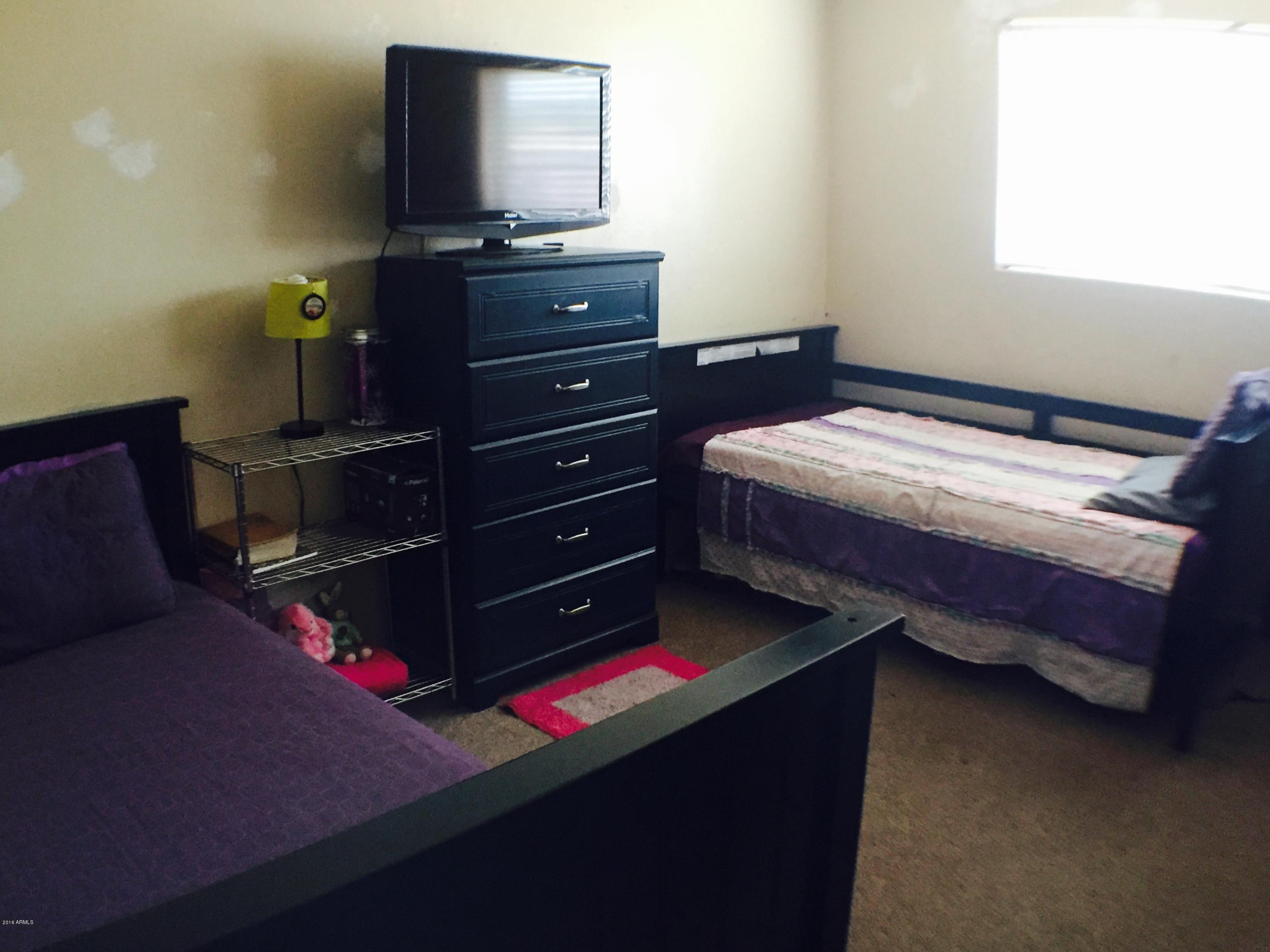 3401 West Ocotillo Road Phoenix, AZ 85017 - Photo 12 of 19 a bed sitting in a bedroom next to a window with dressers