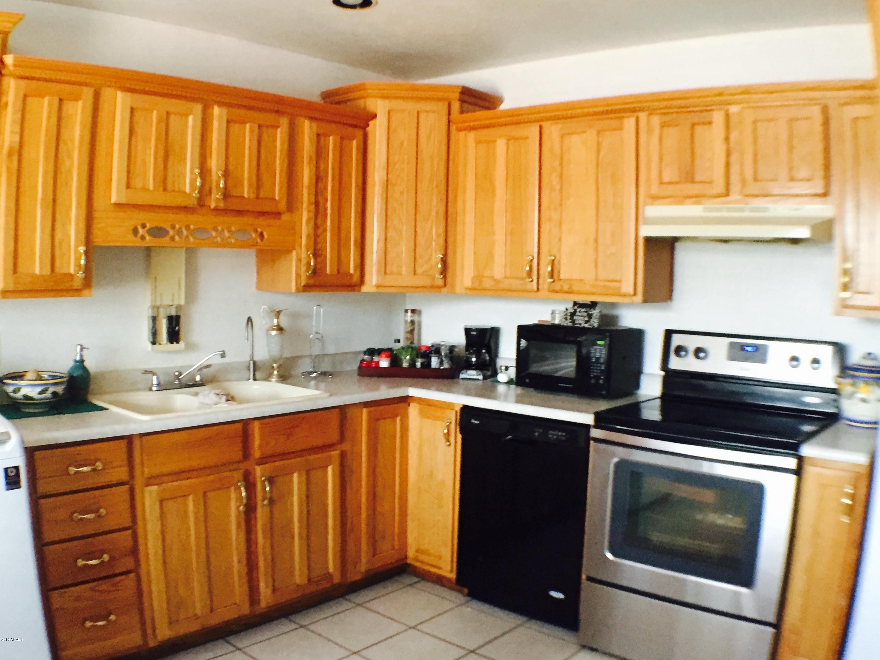 3401 West Ocotillo Road Phoenix, AZ 85017 - Photo 3 of 19 a kitchen with a sink stove top oven and cabinets