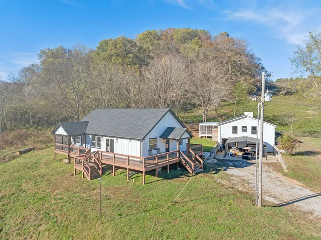 a aerial view of a house with table and chairs under an umbrella